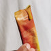 Hand holding an opened Sodii Raw Electrolyte Honey sachet, Salty Honey
