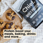 Grass-fed Whey Protein Powder - Creamy Vanilla - 900g by Chief beside freshly baked chocolate chip cookies on parchment paper