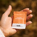 Hand holding a single orange and white sachet of Salty Mandarin - 30 Sachets by Sodii from the Electrolytes collection